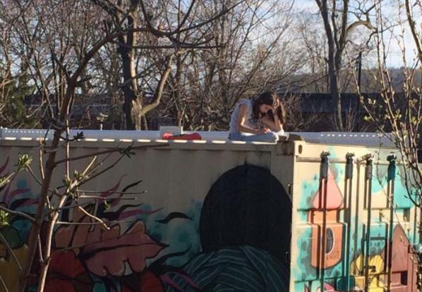 jeune fille lisant sur un toit de garage